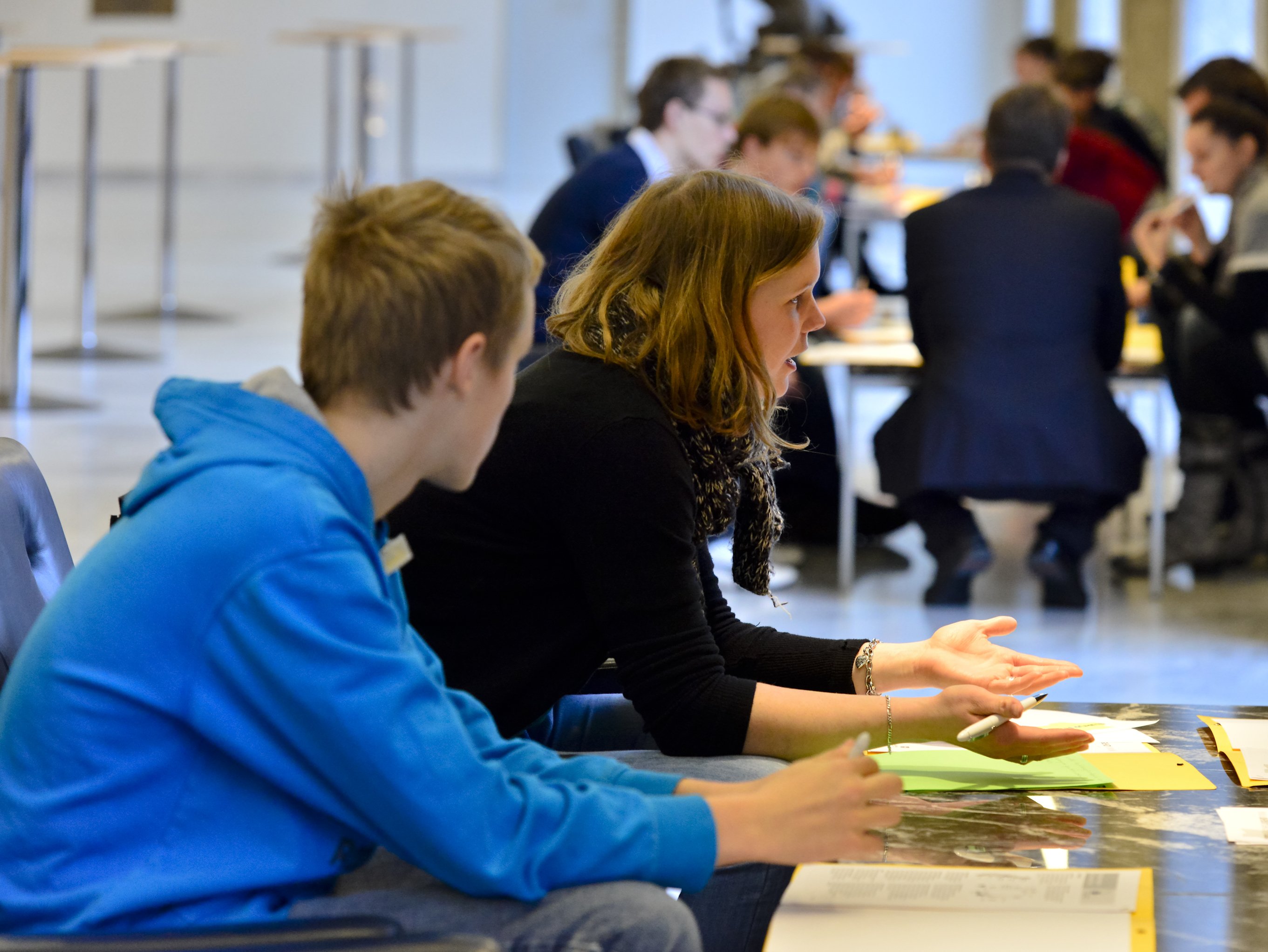 Schülerinnen und Schüler sitzen bei einem Workshop zusammen.