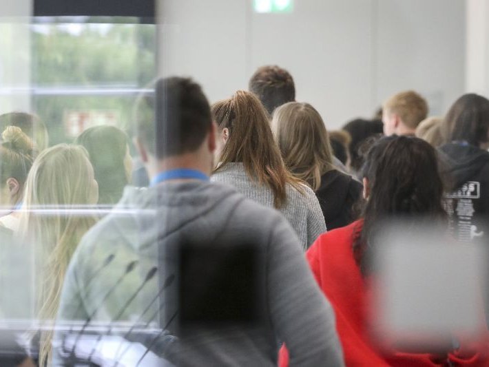 Besucher, die während einer Führung durch die Eingangshalle gehen