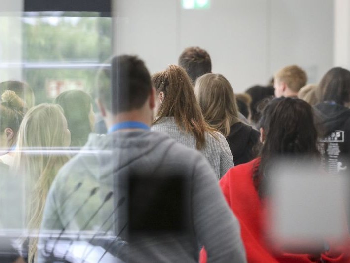 Besucher, die während einer Führung durch die Eingangshalle gehen