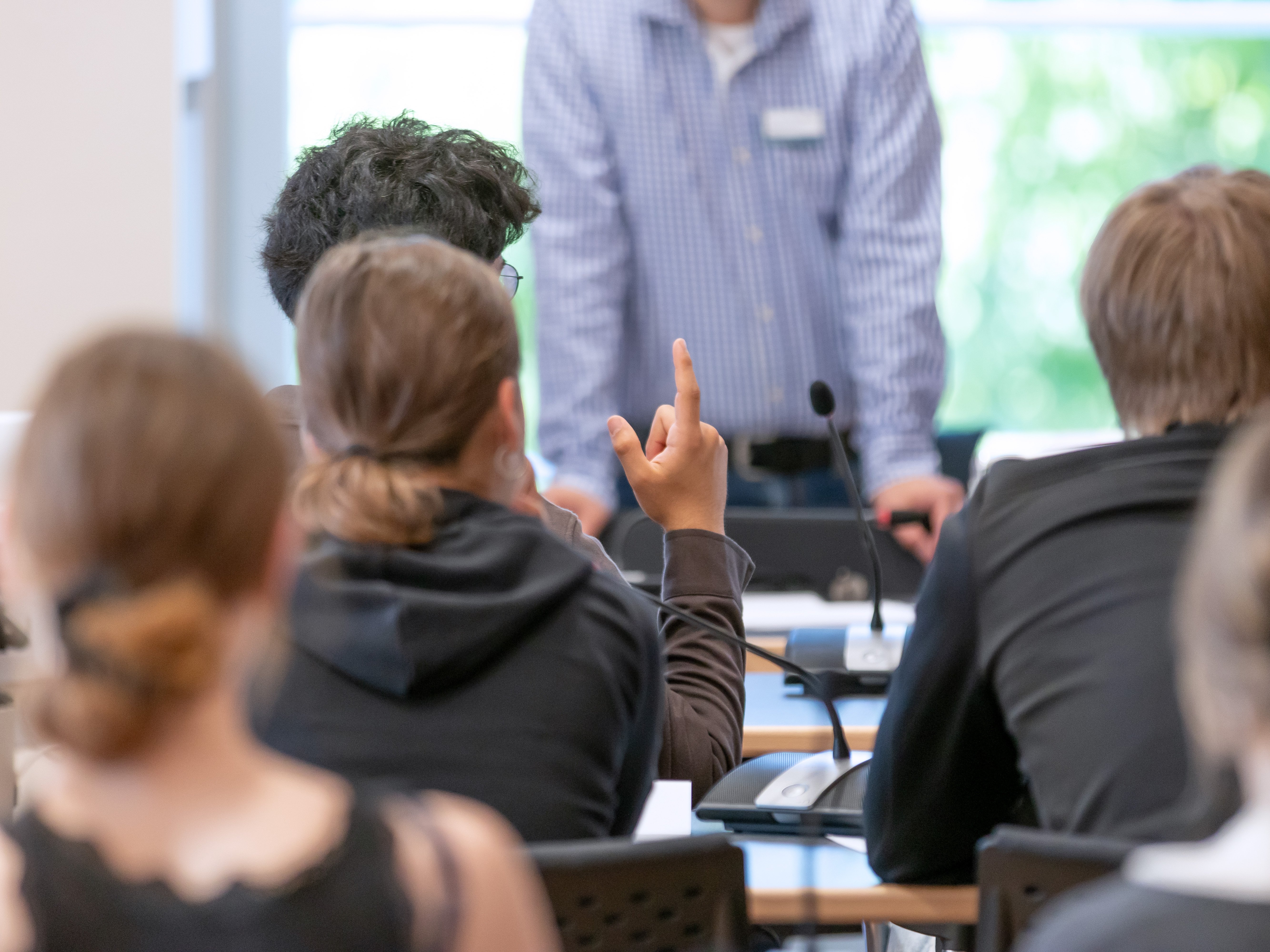 Schülerinnen und Schüler während eines Workshops im Landtag. Eine Person meldet sich per Handzeichen.