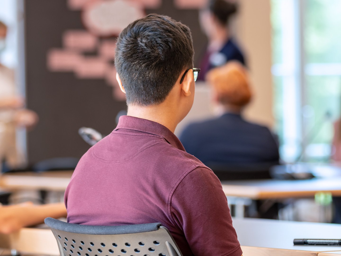 Ein Jugendlicher hört während eines Workshops aufmerksam zu.