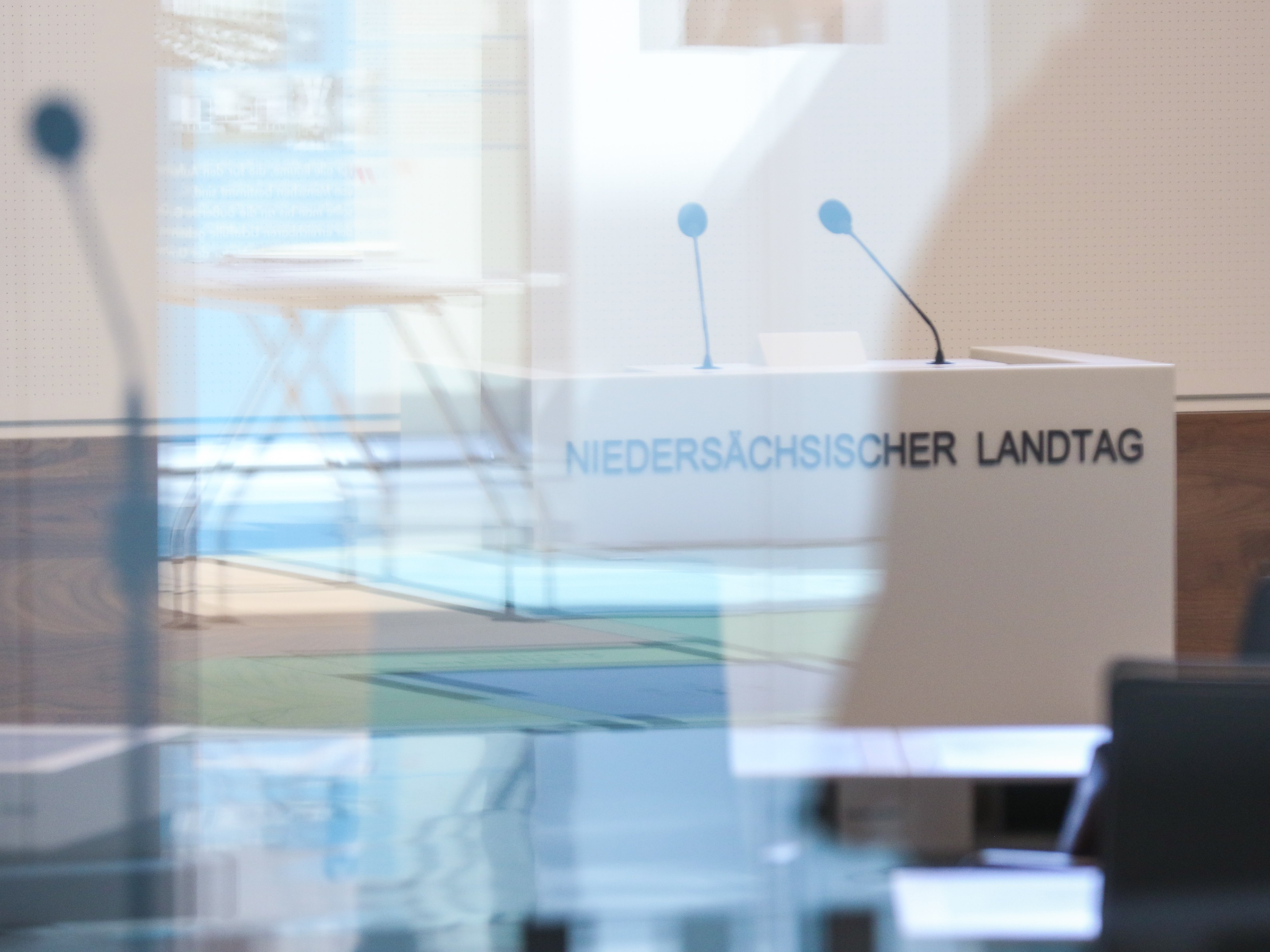 Durch die Glasscheiben des Plenarsaals fotografiertes Rednerpult